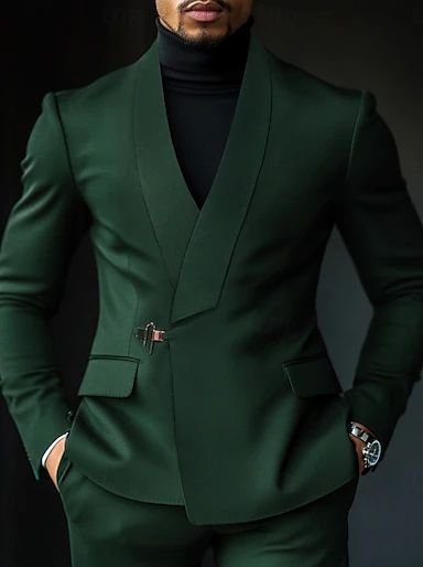 Sharp slim-fit deep forest green modern suit by Attire by Azam, styled with a sophisticated black turtleneck shirt and a custom metallic buckle closure for a powerful corporate or evening look.